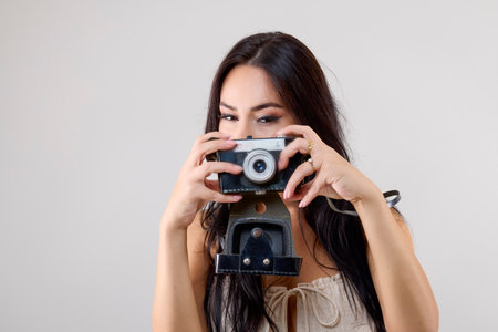 portrait of a beautiful woman with a retro camera isolated on the background.の写真素材