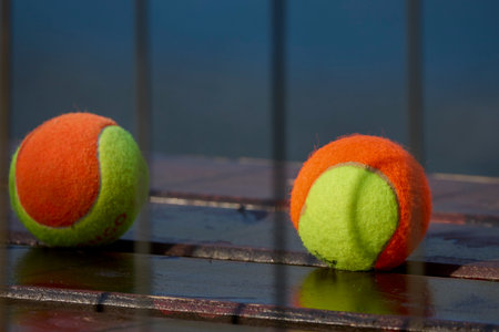 two tennis balls on a bench in a blurred backgroundの写真素材