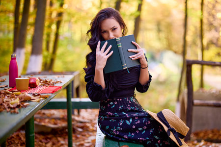a beautiful woman enjoys autumn in the forest at a cottageの写真素材