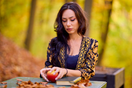 a woman sits at a table in the forestの写真素材