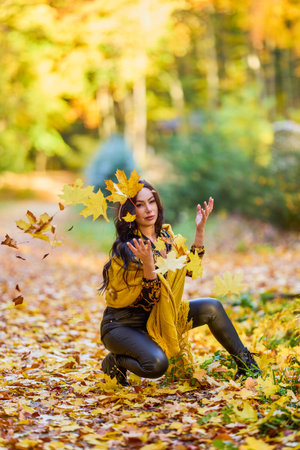 beautiful woman with a blanket enjoys autumn and enjoys the leaves.の写真素材