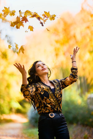 beautiful woman with a blanket enjoys autumn and enjoys the leaves.の写真素材
