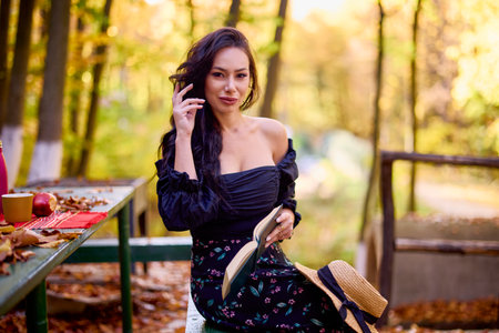 a beautiful woman enjoys autumn in the forest at a cottageの写真素材