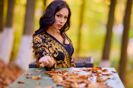 a beautiful woman sits at a table in the forestの写真素材