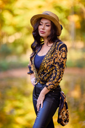 a woman sits on a log near a lake during autumnの写真素材