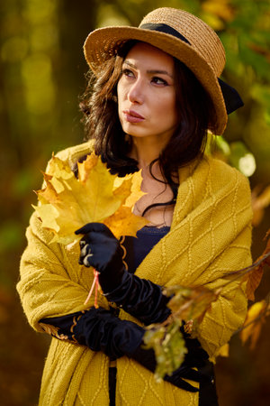 beautiful woman with a blanket enjoys autumn and enjoys the leaves.の写真素材
