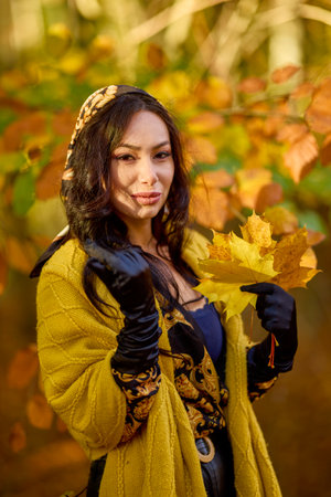 beautiful woman with a blanket enjoys autumn and enjoys the leaves.の写真素材