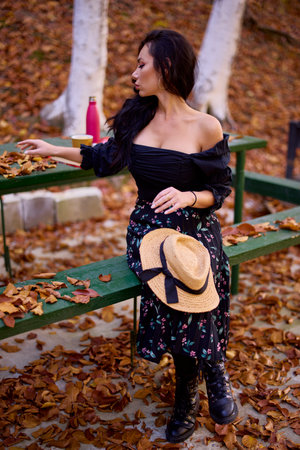 a beautiful woman enjoys autumn in the forest at a cottageの写真素材