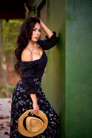 a woman with a hat near a house in autumnの写真素材