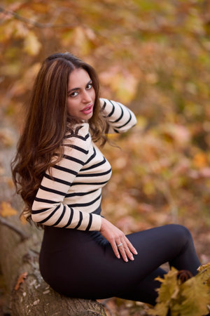 portrait of a beautiful woman with long hair posing in an autumn landscape in a forestの写真素材
