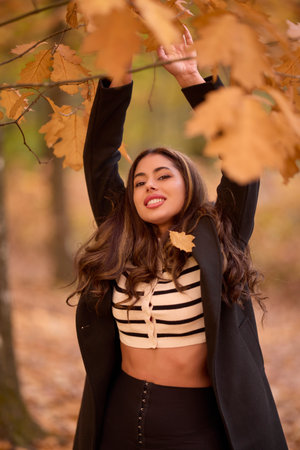 portrait of a beautiful woman with long hair posing in an autumn landscape in a forestの写真素材