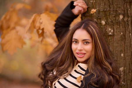 portrait of a beautiful woman with long hair posing in an autumn landscape in a forestの写真素材