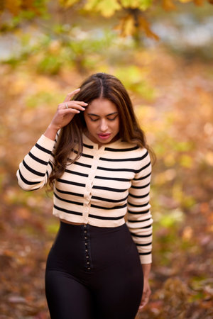 portrait of a beautiful woman with long hair posing in an autumn landscape in a forestの写真素材