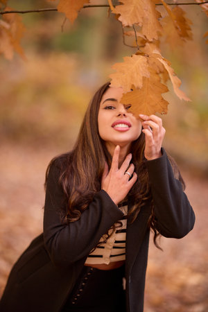 portrait of a beautiful woman with long hair posing in an autumn landscape in a forestの写真素材
