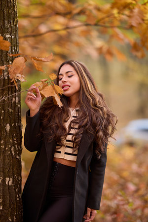 portrait of a beautiful woman with long hair posing in an autumn landscape in a forestの写真素材