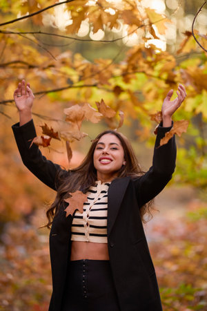 portrait of a beautiful woman with long hair posing in an autumn landscape in a forestの写真素材