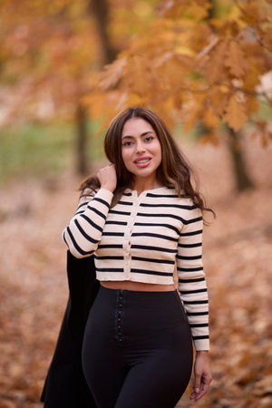 portrait of a beautiful woman with long hair posing in an autumn landscape in a forestの写真素材