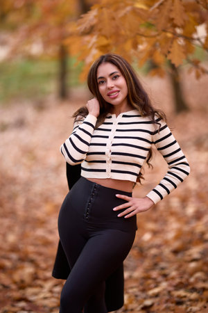 portrait of a beautiful woman with long hair posing in an autumn landscape in a forestの写真素材