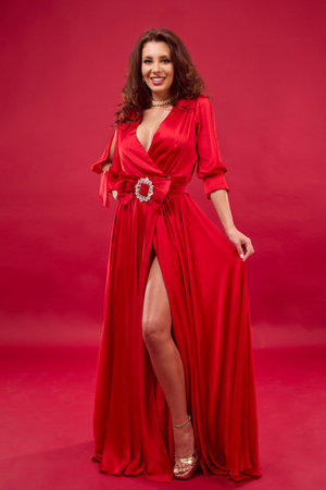 portrait of a woman in a red dress on a red backgroundの写真素材