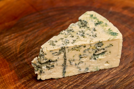 a piece of cheese on a wooden chopping board