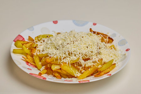 A portion of fries with lots of grated cheese on top