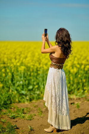 beautiful woman posing in a field of blooming rapeseedの写真素材