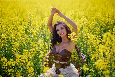 beautiful woman posing in a field of blooming rapeseed