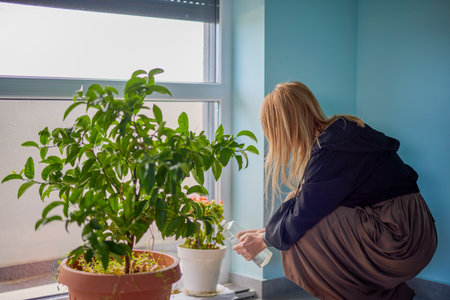 portrait of a woman at the office watering ornamental plants.の写真素材