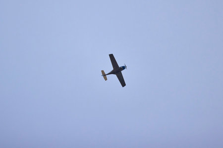 a recreational plane seen from below in the skyの写真素材
