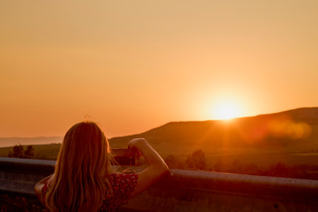 portrait of a woman seen from behind looking at the sunsetの写真素材