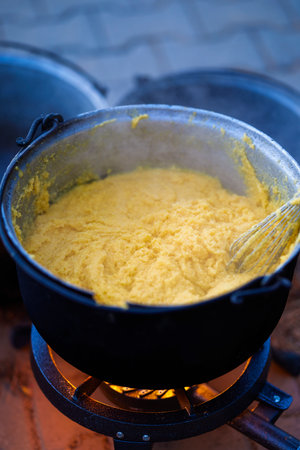 a large pot with polenta cooking on the fireの写真素材