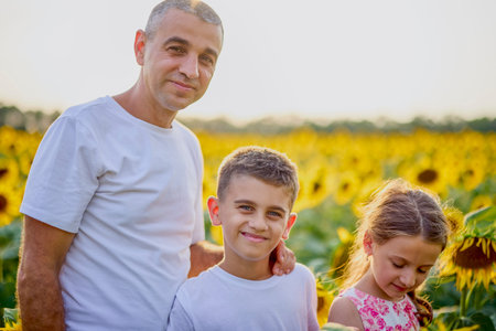 A beautiful family on a farm enjoys a sunflower field together