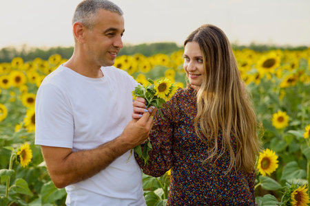 a couple enjoying a sunflower field on a summer dayの写真素材