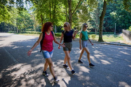 A group of three middle-aged female friends are walking through the forest.