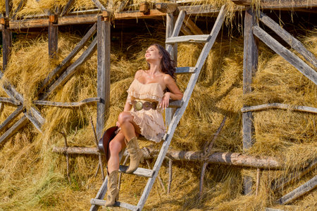 portrait of a woman in country clothes near a straw barnの写真素材