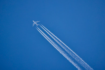 an airplane and the traces it leaves on a blue sky.の写真素材