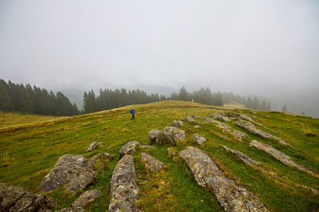 a middle-aged man climbing a mountain on a cloudy and foggy day