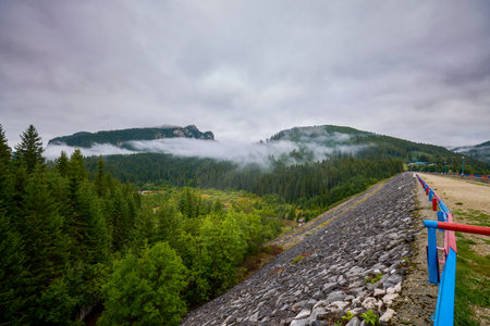 a beautiful mountain landscape on a September day with clouds and fog.