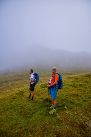 tourists on a mountain trail on a cloudy autumn day