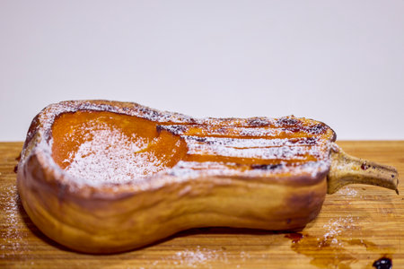 half a pumpkin baked in the oven and sprinkled with powdered sugarの写真素材