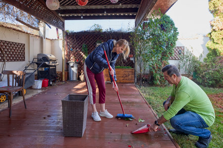 a woman and a man on the terrace at home cleaning the terraceの写真素材