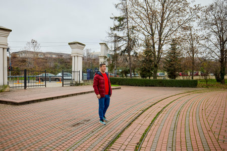 A middle-aged man walks through the park in the morning and relaxes on a late autumn day.