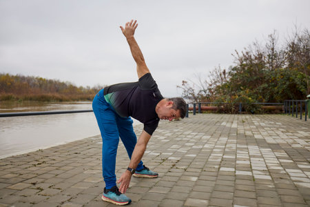 A middle-aged man does morning warm-up exercises and runs.