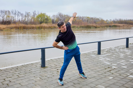 A middle-aged man does morning warm-up exercises and runs.