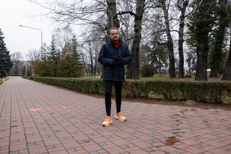 A man walks through the park on a late autumn day.