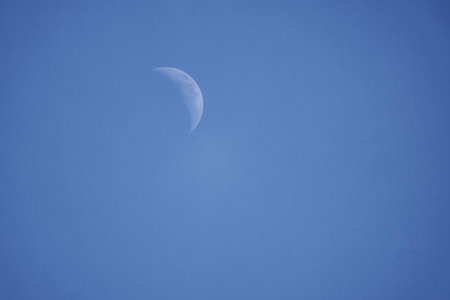 beautiful landscape with the crescent moon seen in the sky during the day