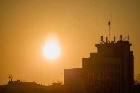 Landscape with sunset in the urban area above a city over buildings and churchの写真素材