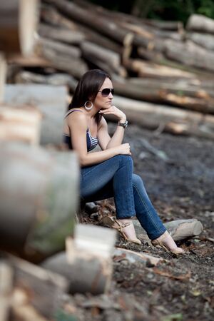 beautiful woman siting on trunkの写真素材