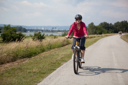 young woman riding a bikeの写真素材