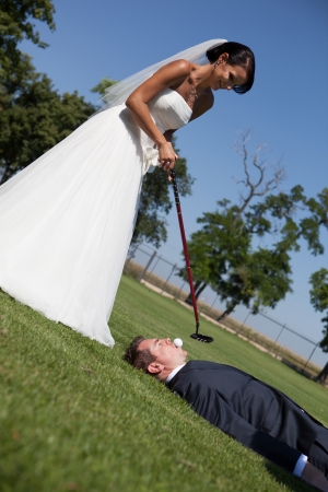 Bride and groom playing golf の写真素材